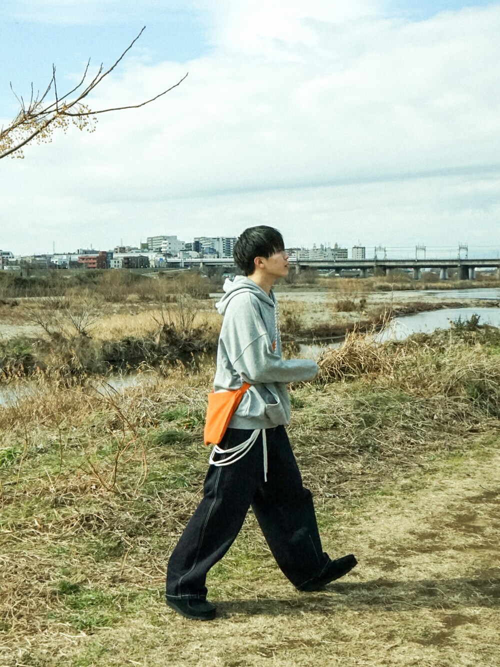 グレー系のパーカー、ブルー系のデニムパンツ、ブラック系のその他シューズを着用したメンズの冬コーディネートの3枚目の写真