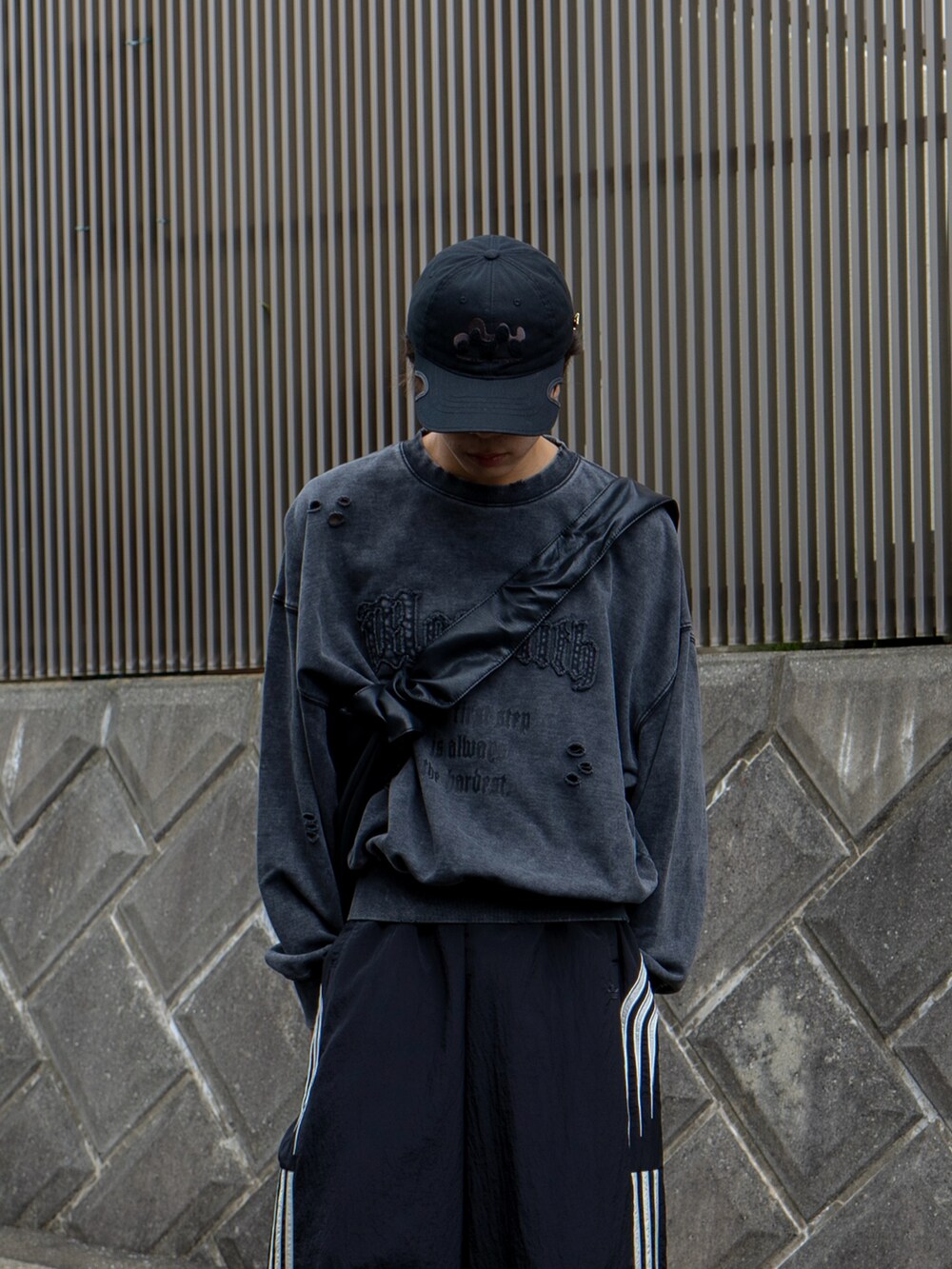 グレー系のスウェット、ブラック系のショルダーバッグ、ブラック系のスウェットパンツを着用したメンズの秋コーディネートの3枚目の写真