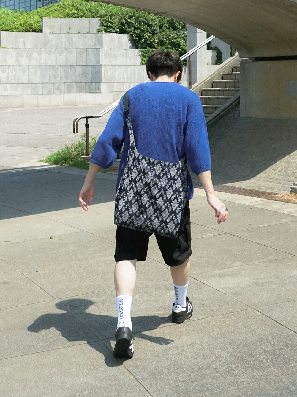 ブルー系のショルダーバッグ、ブラック系のスニーカー、ブルー系のその他を着用したメンズの夏コーディネートの2枚目の写真