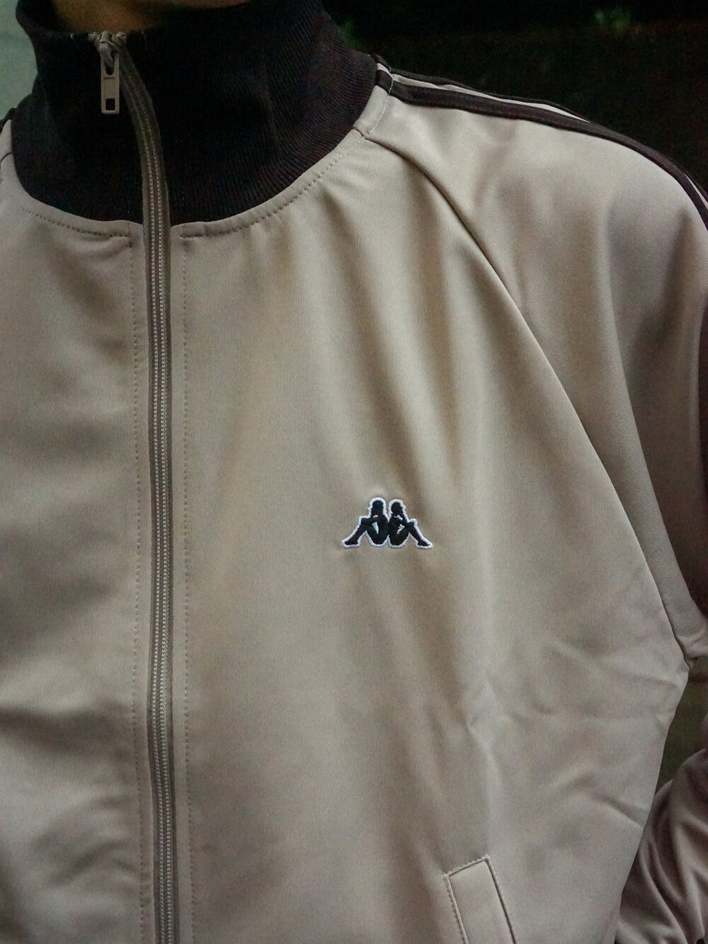 ベージュ系のジャージ、ブラック系のデニムパンツ、ホワイト系のバッグを着用したメンズの秋コーディネートの4枚目の写真