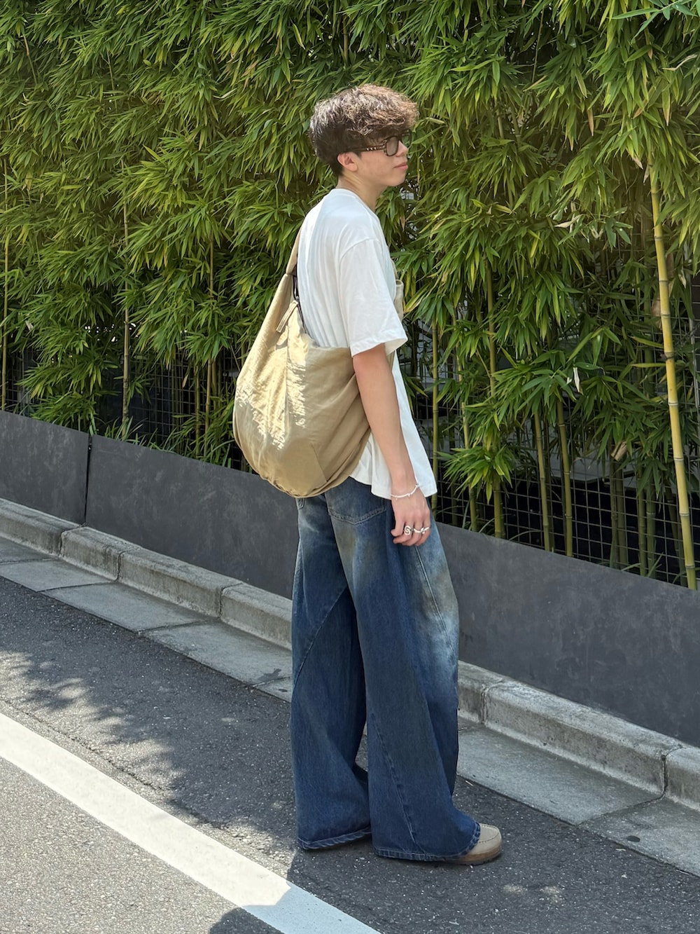 ベージュ系のその他シューズ、ブルー系のデニムパンツ、ベージュ系のショルダーバッグを着用したメンズの夏コーディネートの2枚目の写真