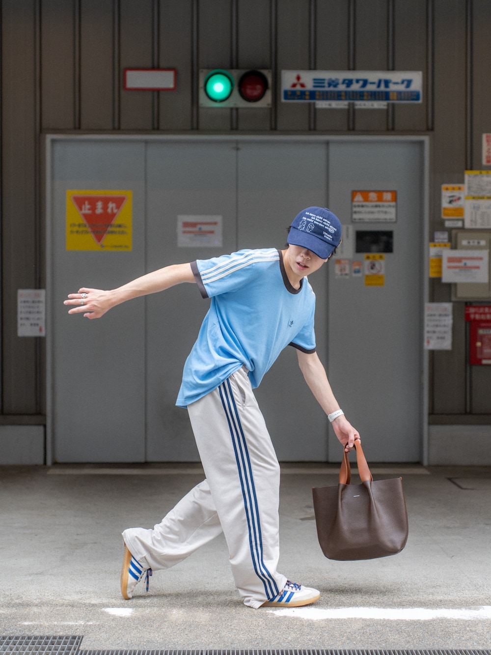 ブルー系のTシャツ/カットソー、ホワイト系のその他パンツ、ブラウン系のハンドバッグを着用したメンズの夏コーディネートの3枚目の写真