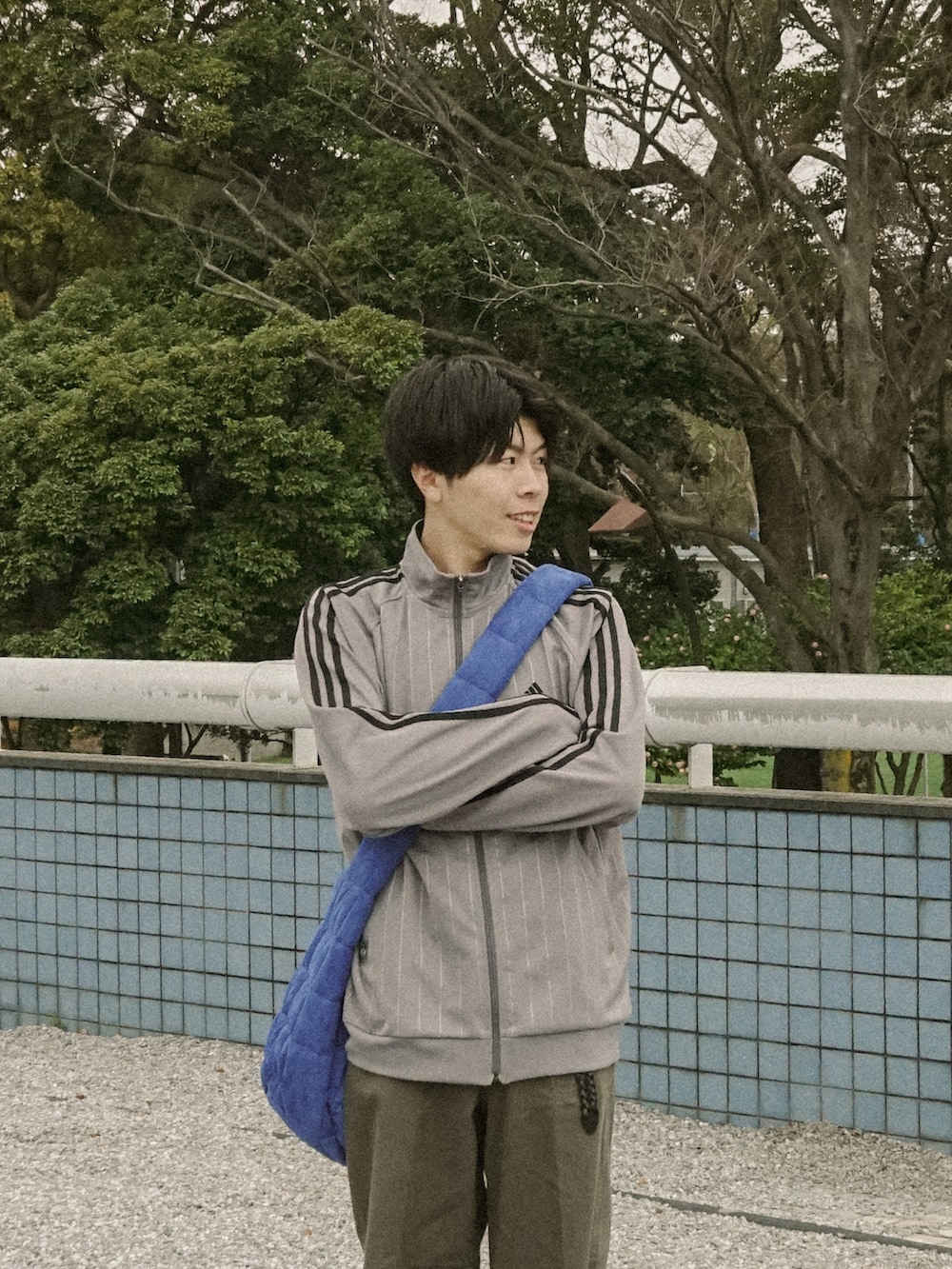 ブラウン系のその他パンツ、ブルー系のショルダーバッグ、ブラック系のその他シューズを着用したメンズの春コーディネートの2枚目の写真