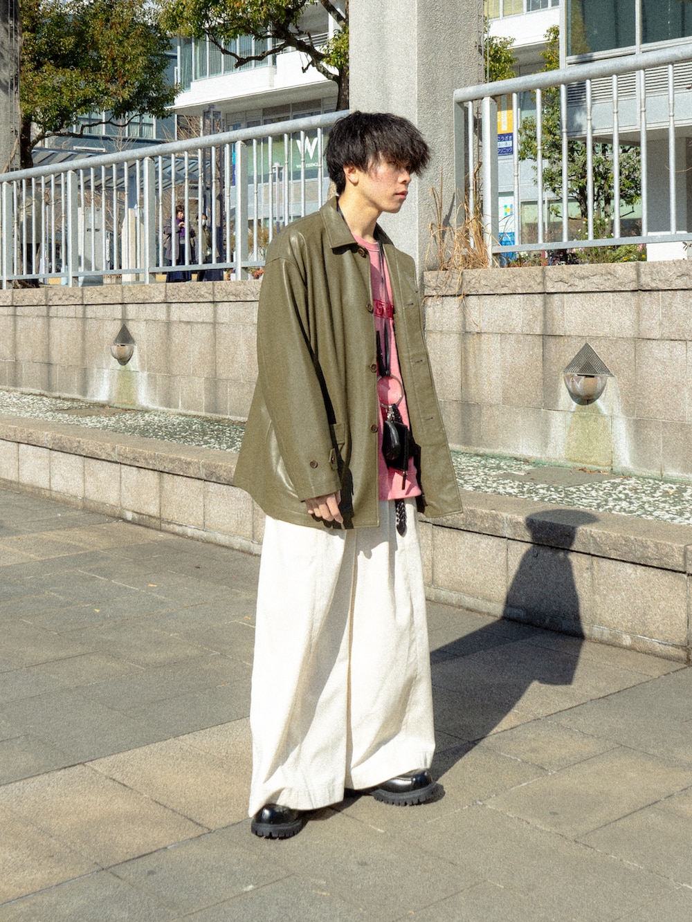 ブラック系のカバーオール、ピンク系のスウェット、ホワイト系のその他パンツを着用したメンズの冬コーディネートの2枚目の写真