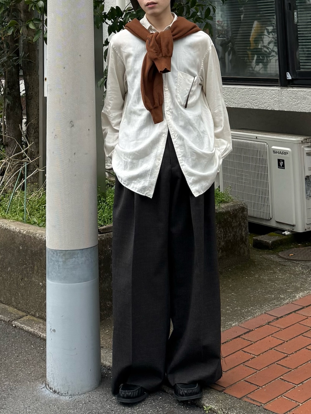 ブラウン系のカーディガン/ボレロ、ブラウン系のスラックス、ブラック系のローファーを着用したメンズの春コーディネートの5枚目の写真