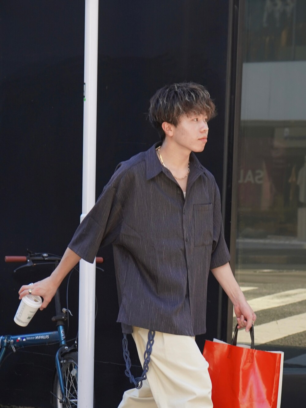 グレー系のシャツ/ブラウス、ホワイト系のトートバッグ、ブラック系のスニーカーを着用したメンズの夏コーディネートの4枚目の写真