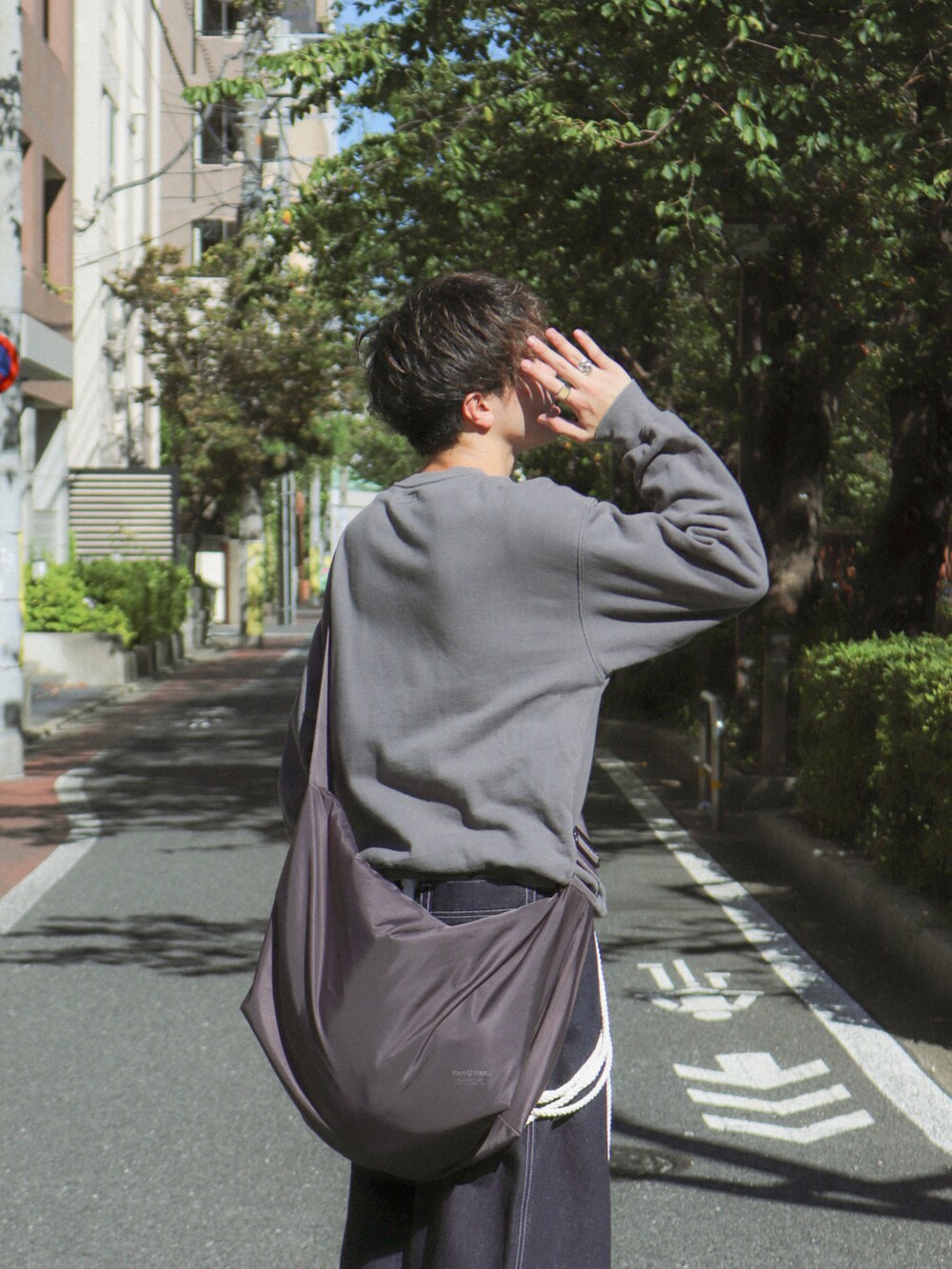 ブルー系のデニムパンツ、グレー系のショルダーバッグ、ブラック系のその他シューズを着用したメンズの秋コーディネートの4枚目の写真