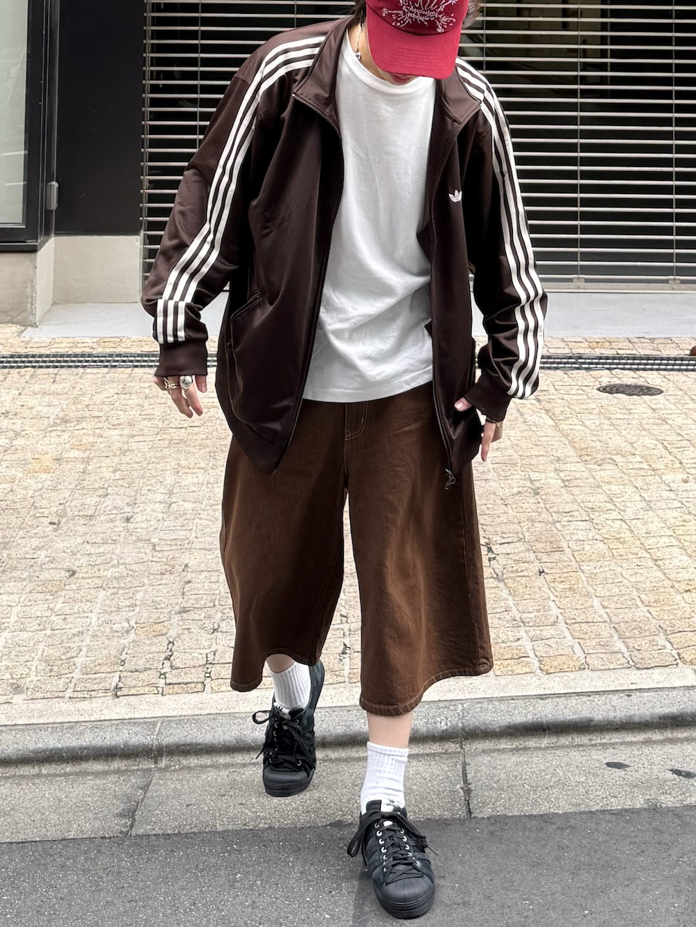 ブラウン系のジャージ、ホワイト系のTシャツ/カットソー、ブラウン系のデニムパンツを着用したメンズの春コーディネートの5枚目の写真