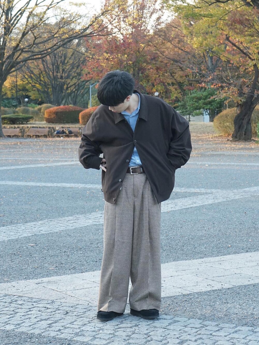 ブラウン系のブルゾン、ブルー系のシャツ/ブラウス、ベージュ系のスラックスを着用したメンズの秋コーディネートの4枚目の写真