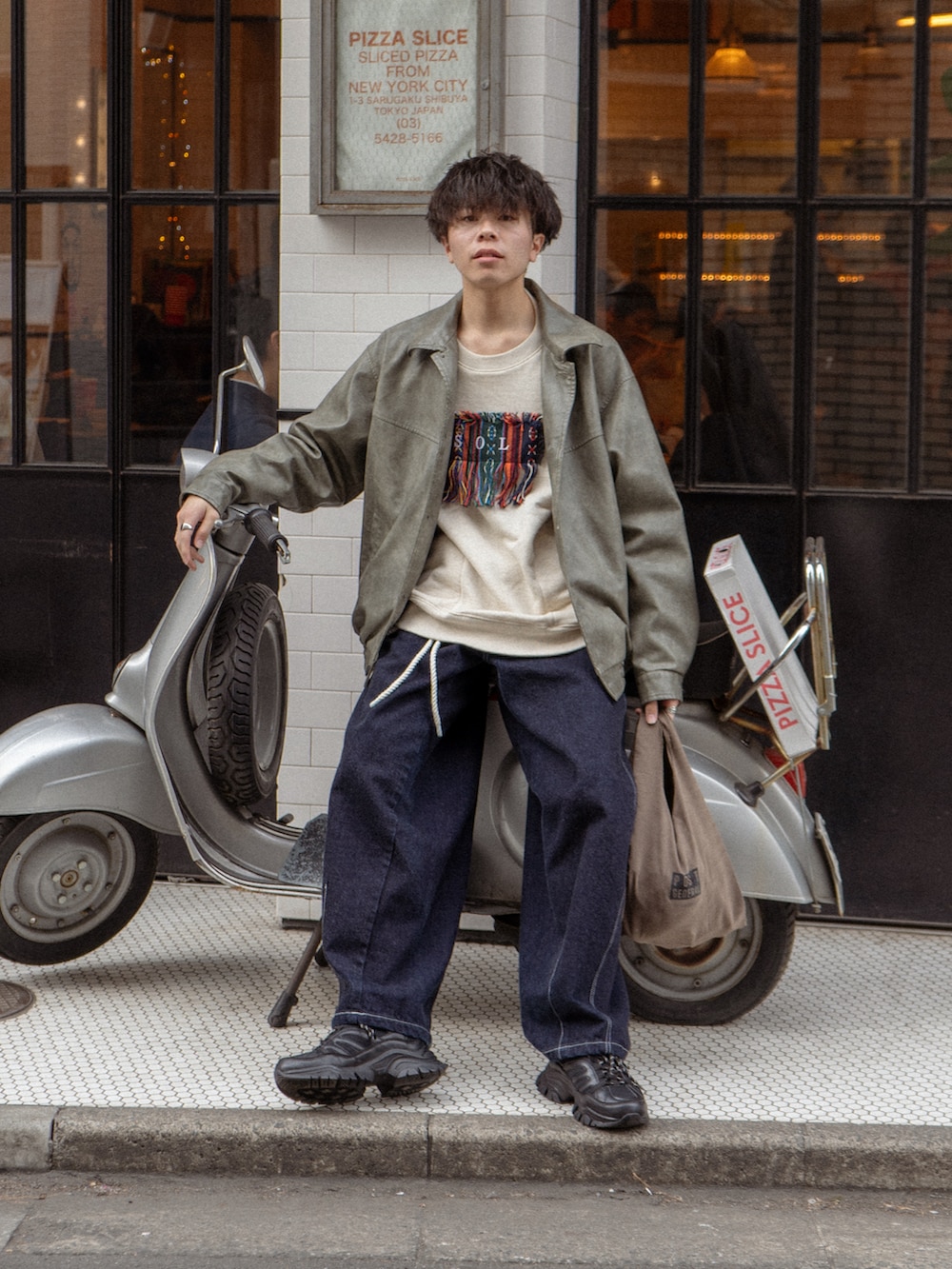 グレー系のブルゾン、ホワイト系のスウェット、ブルー系のデニムパンツを着用したメンズの冬コーディネートの2枚目の写真