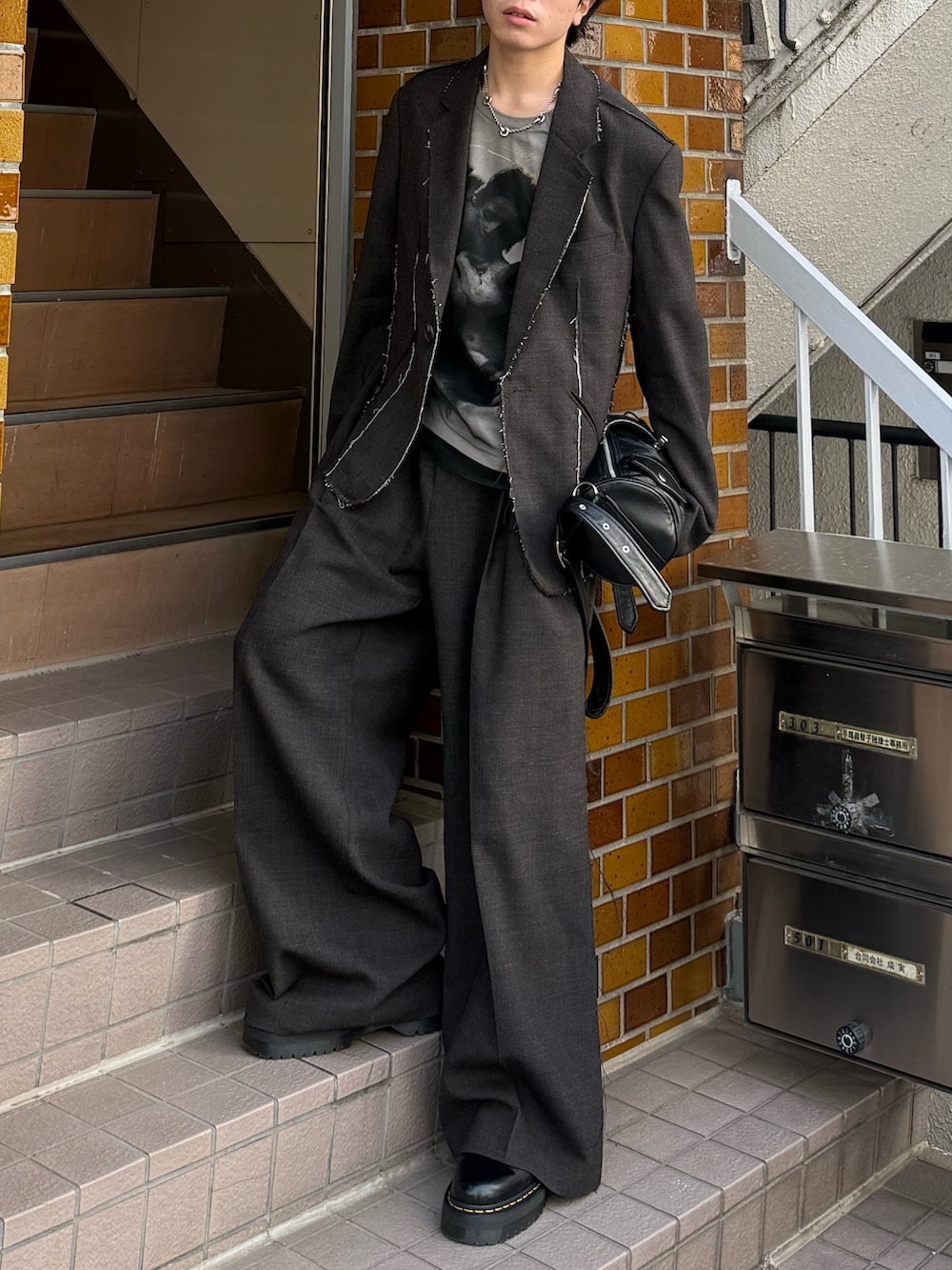 ブラック系のブーツ、ホワイト系のTシャツ/カットソー、ブラック系のショルダーバッグを着用したメンズの春コーディネートの4枚目の写真