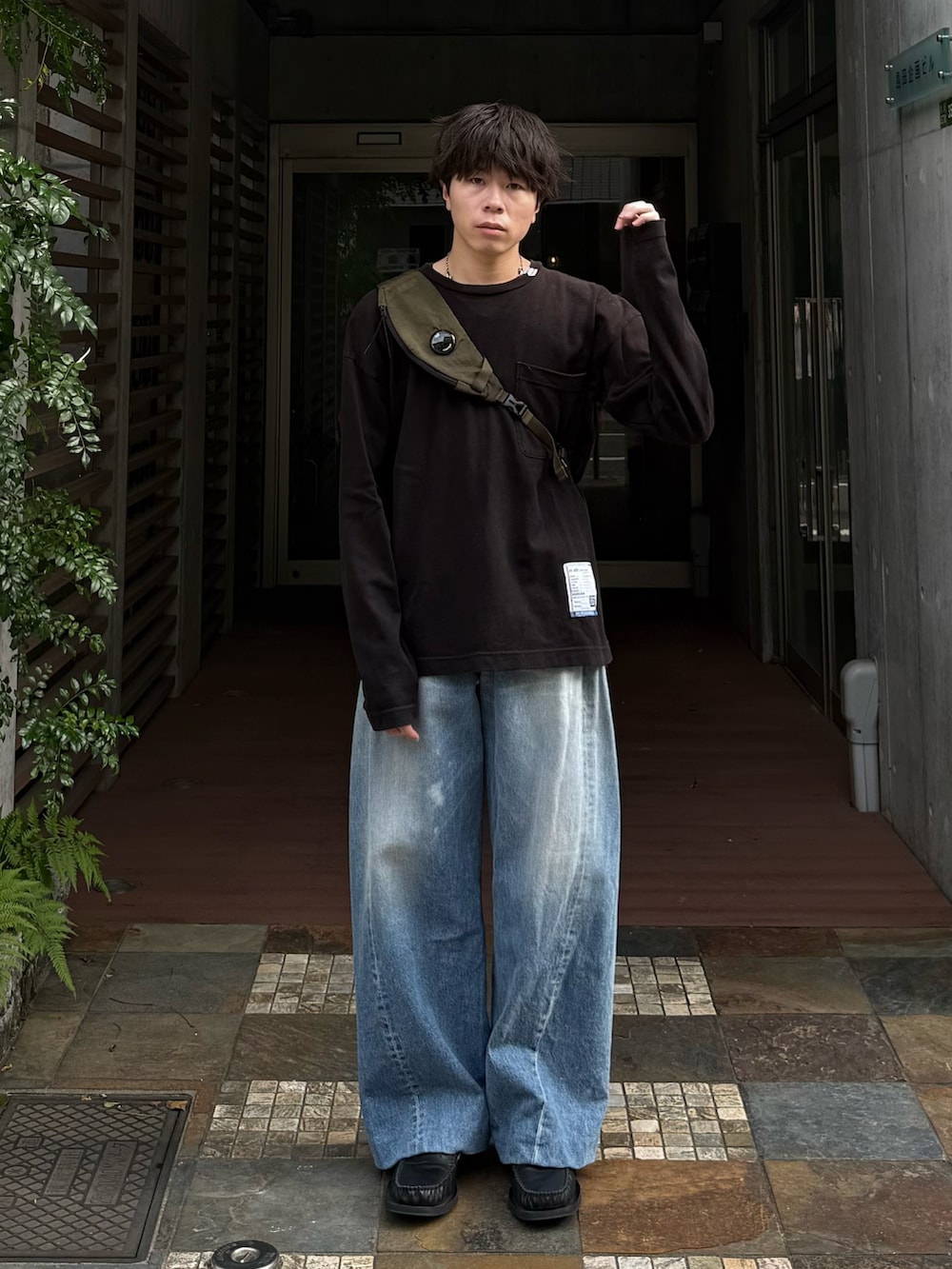 ブラック系のTシャツ/カットソー、ブルー系のデニムパンツ、グリーン系のバックパック/リュックを着用したメンズの夏コーディネートの2枚目の写真