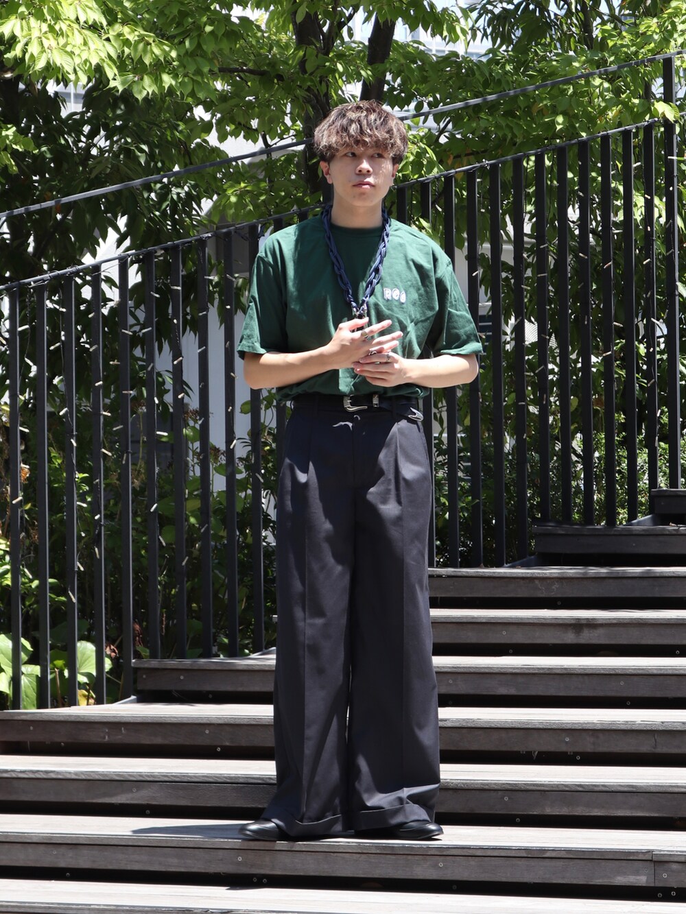 グリーン系のTシャツ/カットソー、グレー系のスラックス、ブルー系のウォレットチェーンを着用したメンズの夏コーディネートの2枚目の写真