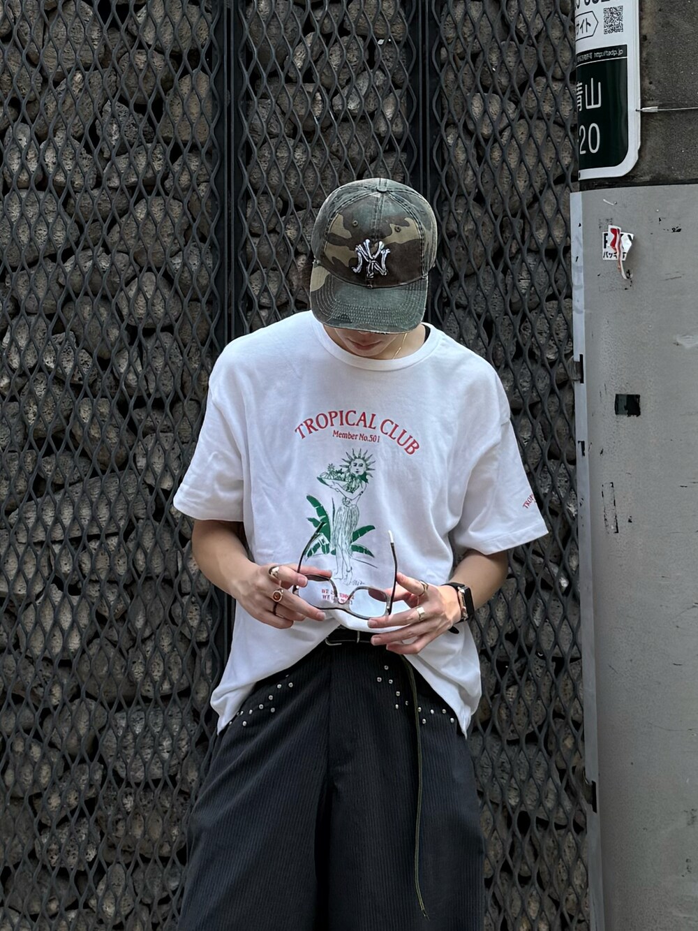 ホワイト系のTシャツ/カットソー、グレー系のスラックス、ブラック系のスニーカーを着用したメンズの夏コーディネートの3枚目の写真