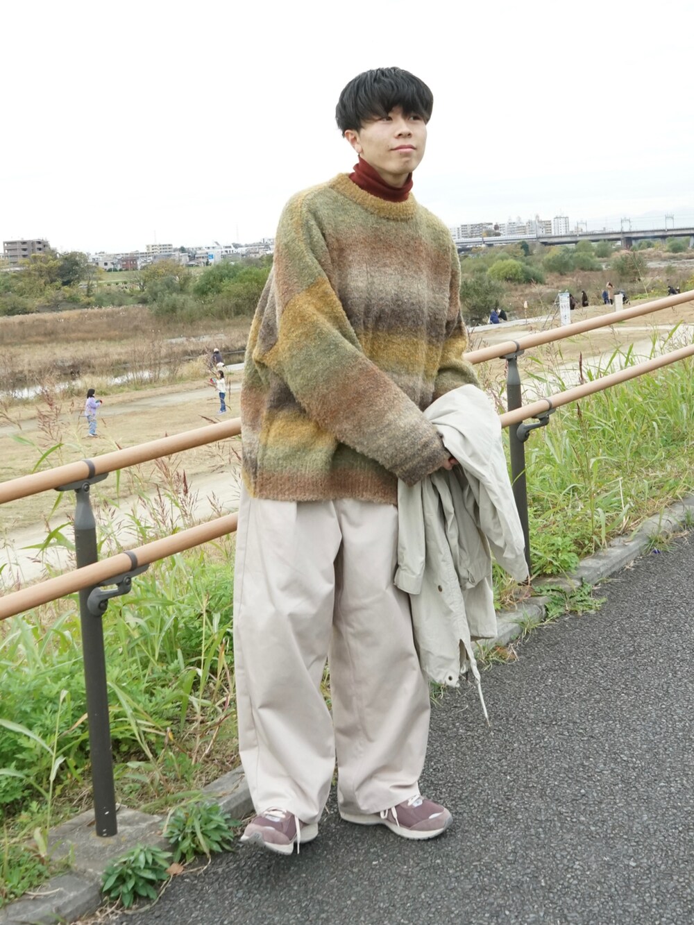 グリーン系のニット/セーター、レッド系のTシャツ/カットソー、ベージュ系のモッズコートを着用したメンズの冬コーディネートの2枚目の写真