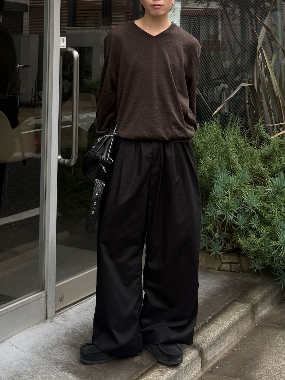 ブラック系のその他パンツ、ブラック系のショルダーバッグ、ブラック系のモカシン/デッキシューズを着用したメンズの春コーディネートの5枚目の写真