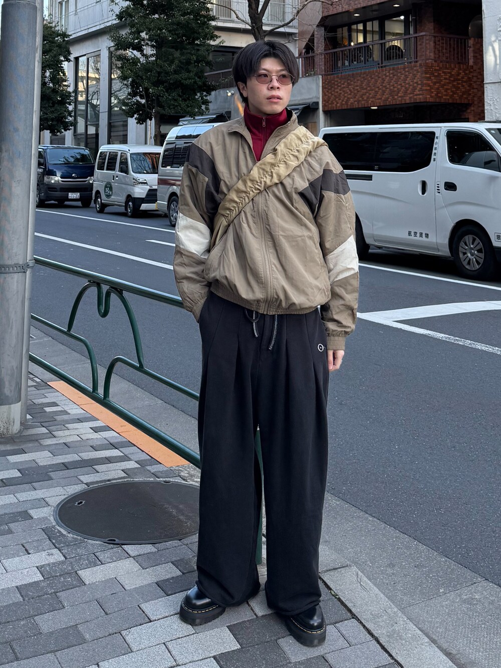 レッド系のその他トップス、ブラック系のブーツ、ベージュ系のナイロンジャケットを着用したメンズの春コーディネートの2枚目の写真