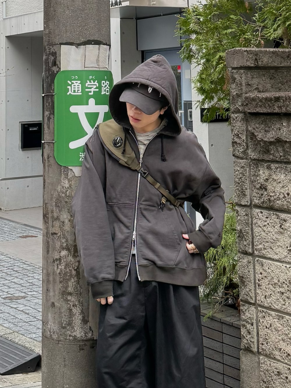 ブラック系のパーカー、グレー系のTシャツ/カットソー、グリーン系のバックパック/リュックを着用したメンズの春コーディネートの3枚目の写真