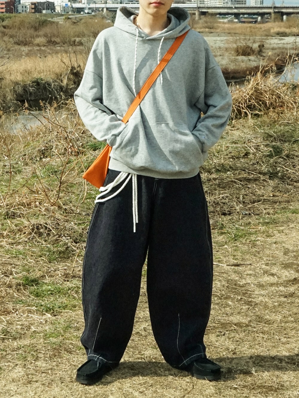 グレー系のパーカー、ブルー系のデニムパンツ、ブラック系のその他シューズを着用したメンズの冬コーディネートの5枚目の写真