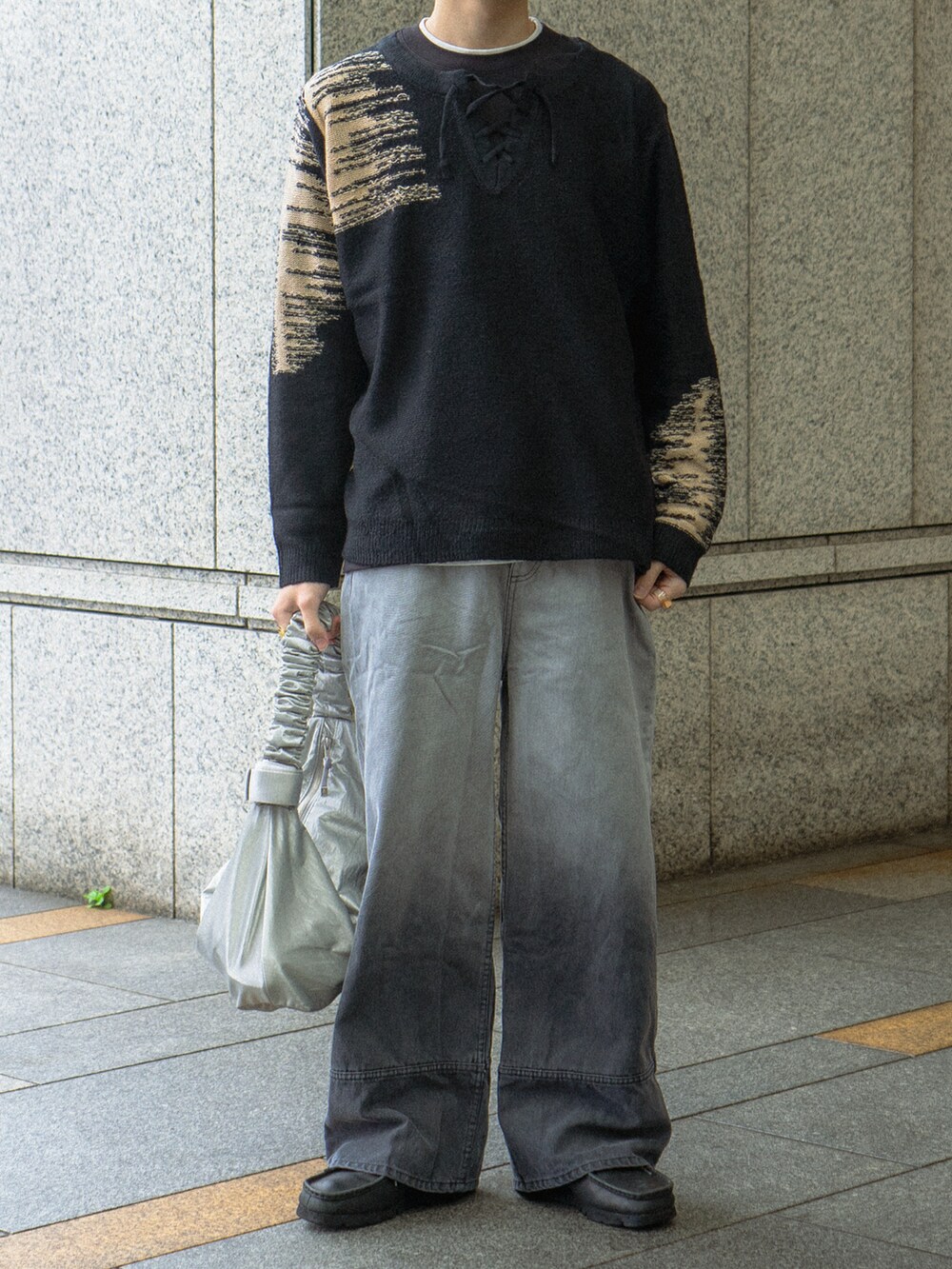 ブラック系のニット/セーター、ブラック系のデニムパンツ、ブラック系のブーツを着用したメンズの春コーディネートの5枚目の写真