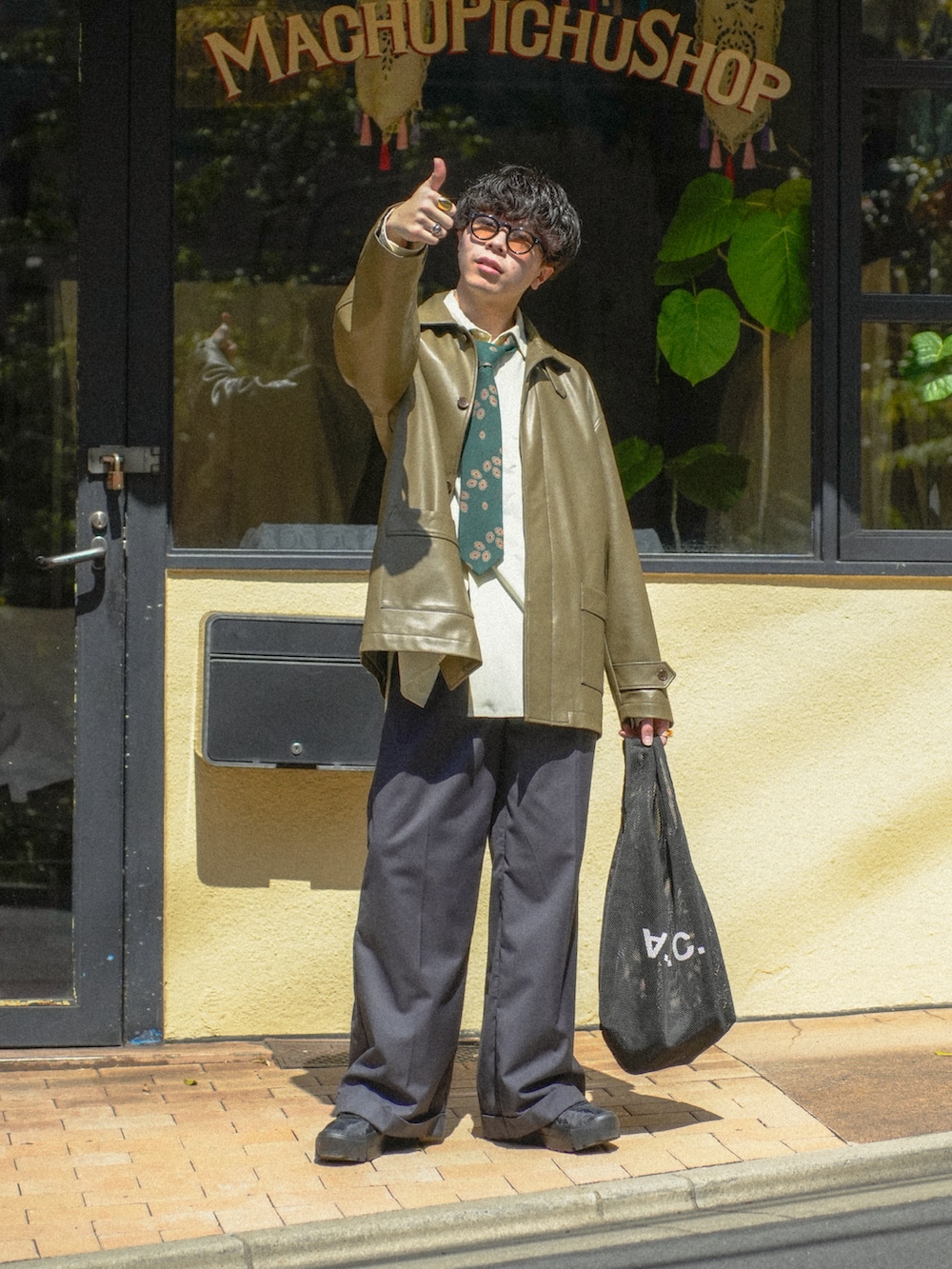 ブラック系のカバーオール、イエロー系のシャツ/ブラウス、グレー系のスラックスを着用したメンズの春コーディネートの2枚目の写真