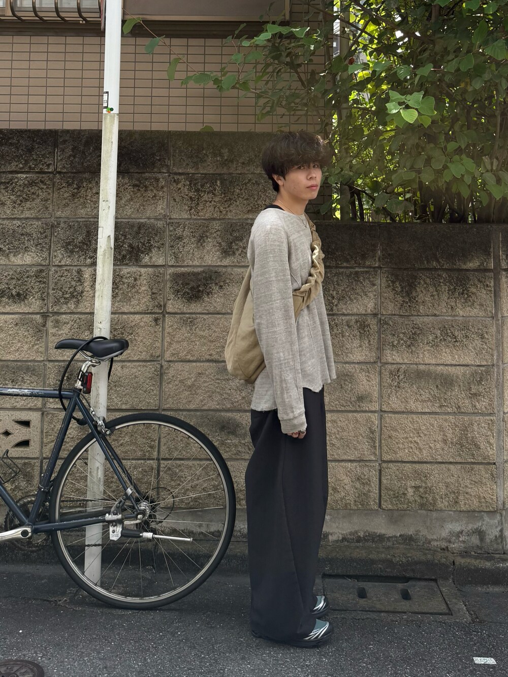 グレー系のTシャツ/カットソー、ブルー系のタンクトップ、グレー系のスラックスを着用したメンズの秋コーディネートの2枚目の写真