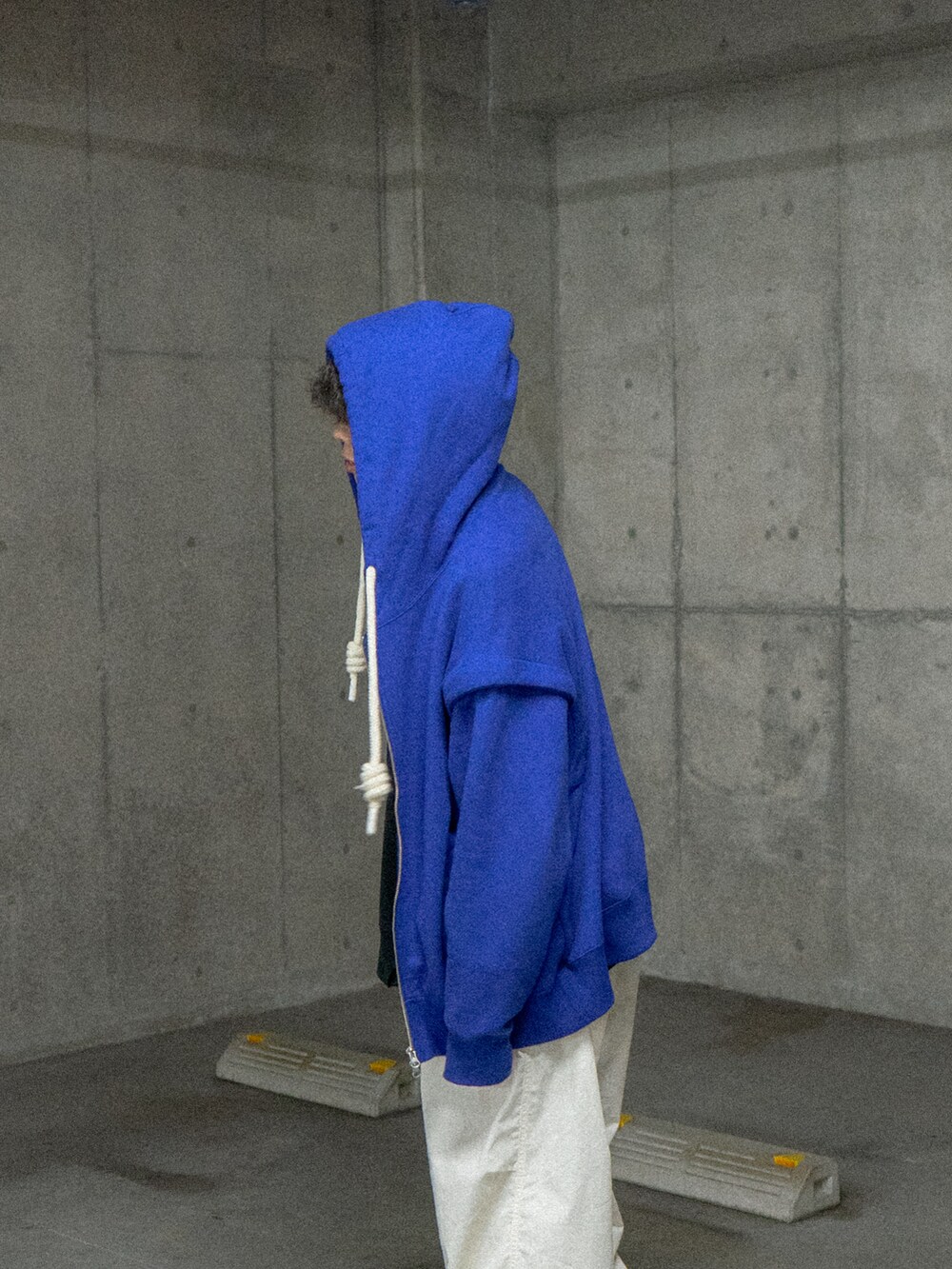 ブルー系のパーカー、ホワイト系のカーゴパンツ、ブラック系のスニーカーを着用したメンズの冬コーディネートの4枚目の写真