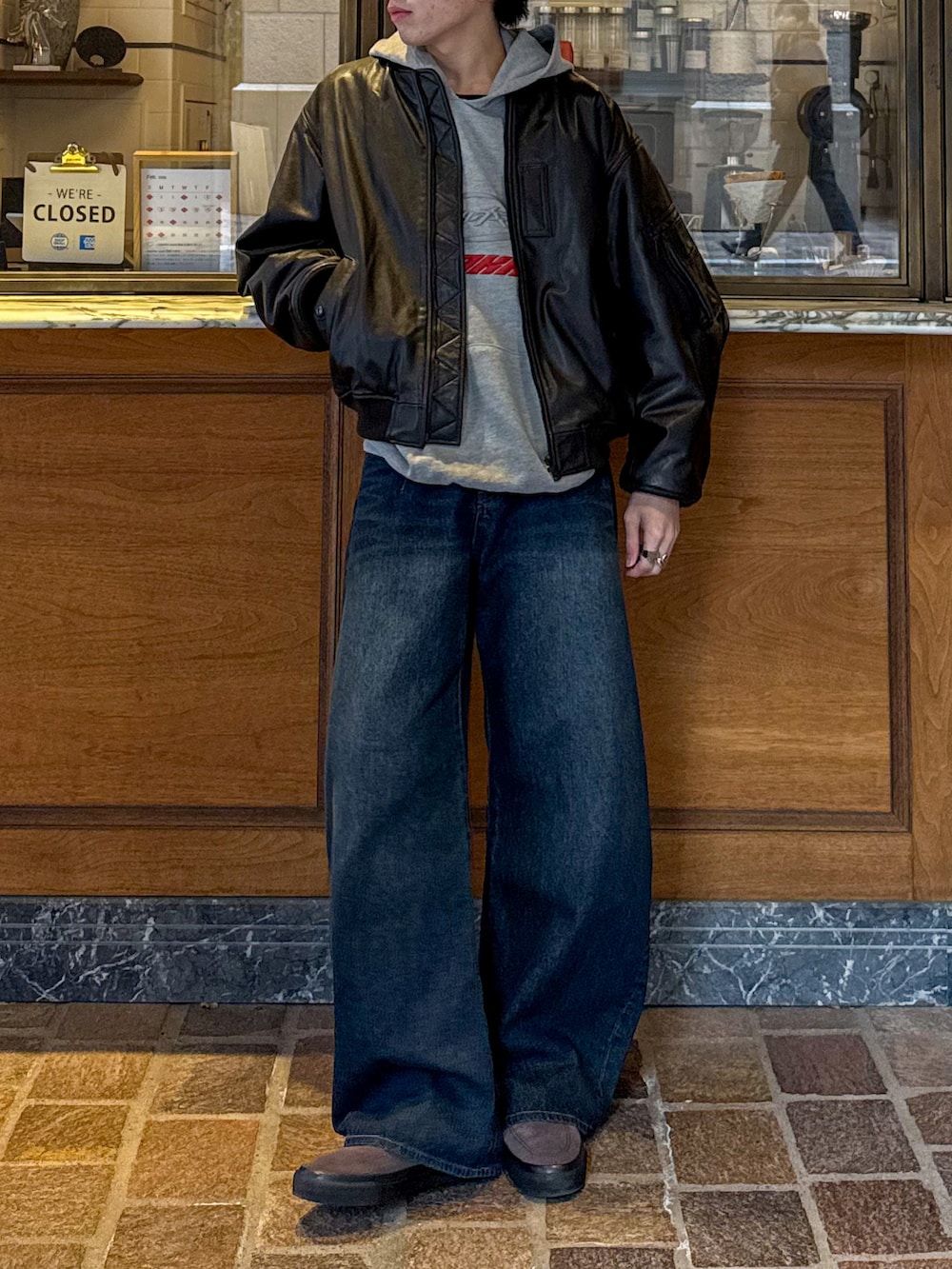 ブラウン系のMA-1、ブルー系のデニムパンツ、グレー系のパーカーを着用したメンズの冬コーディネートの4枚目の写真