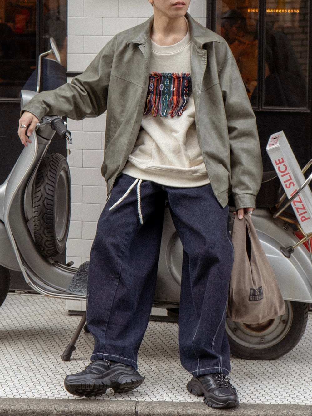 グレー系のブルゾン、ホワイト系のスウェット、ブルー系のデニムパンツを着用したメンズの冬コーディネートの5枚目の写真