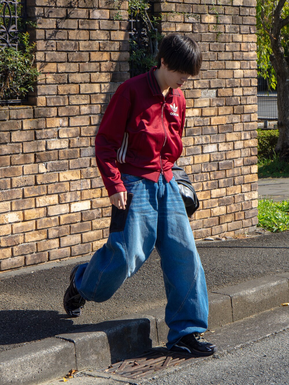 レッド系のその他トップス、ブルー系のデニムパンツ、ブラック系のブルゾンを着用したメンズの秋コーディネートの2枚目の写真