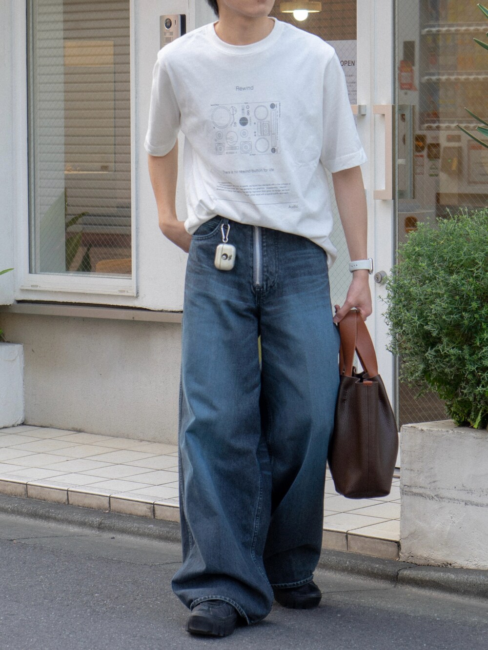その他のTシャツ/カットソー、ブルー系のデニムパンツ、ブラウン系のハンドバッグを着用したメンズの夏コーディネートの4枚目の写真