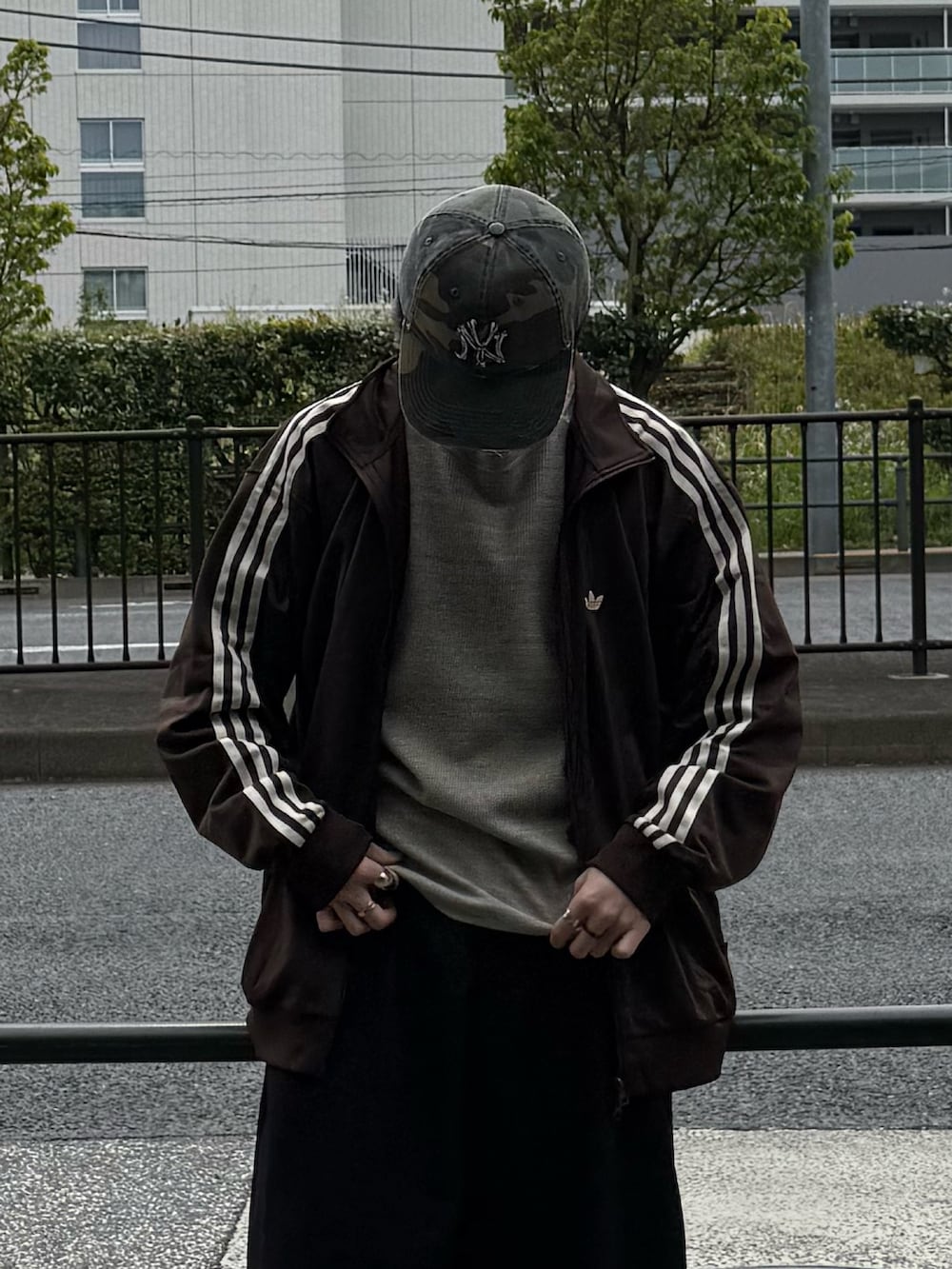 ブラウン系のジャージ、グレー系のTシャツ/カットソー、ブラック系のスラックスを着用したメンズの春コーディネートの3枚目の写真