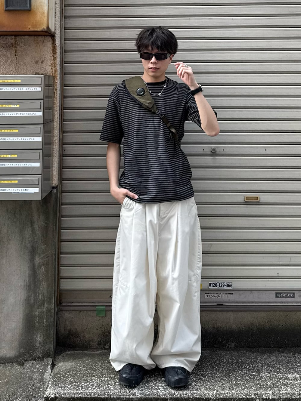 ブラック系のTシャツ/カットソー、ホワイト系のその他パンツ、ブラック系のスニーカーを着用したメンズの夏コーディネートの2枚目の写真