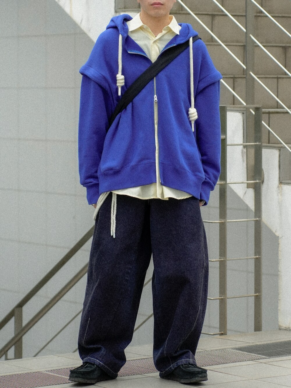 ブルー系のパーカー、イエロー系のシャツ/ブラウス、ブルー系のデニムパンツを着用したメンズの春コーディネートの5枚目の写真