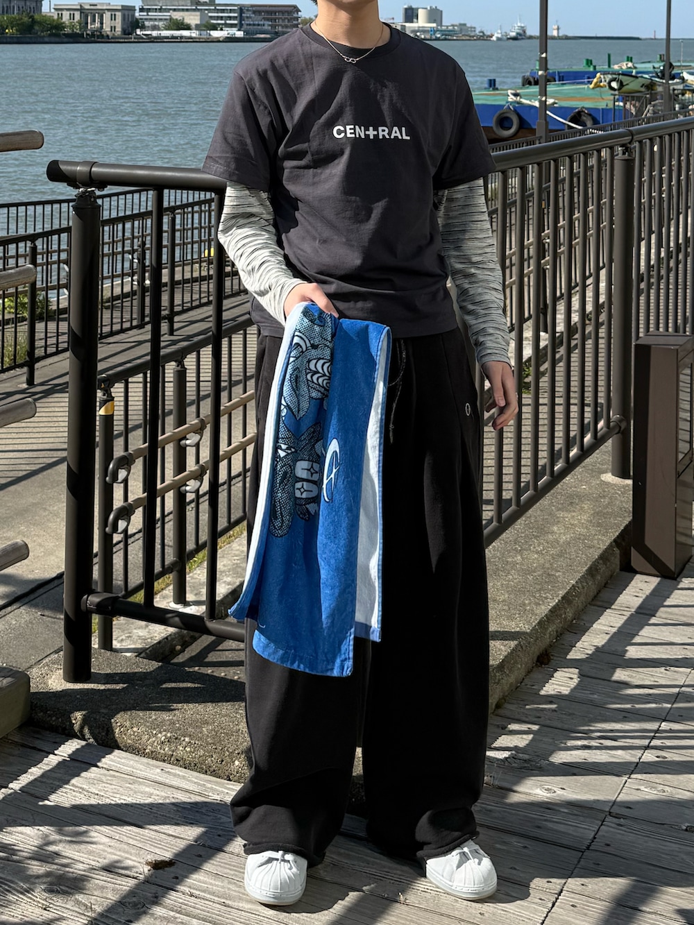グレー系のTシャツ/カットソー、ブラック系のスウェットパンツ、グレー系のスニーカーを着用したメンズの春コーディネートの4枚目の写真