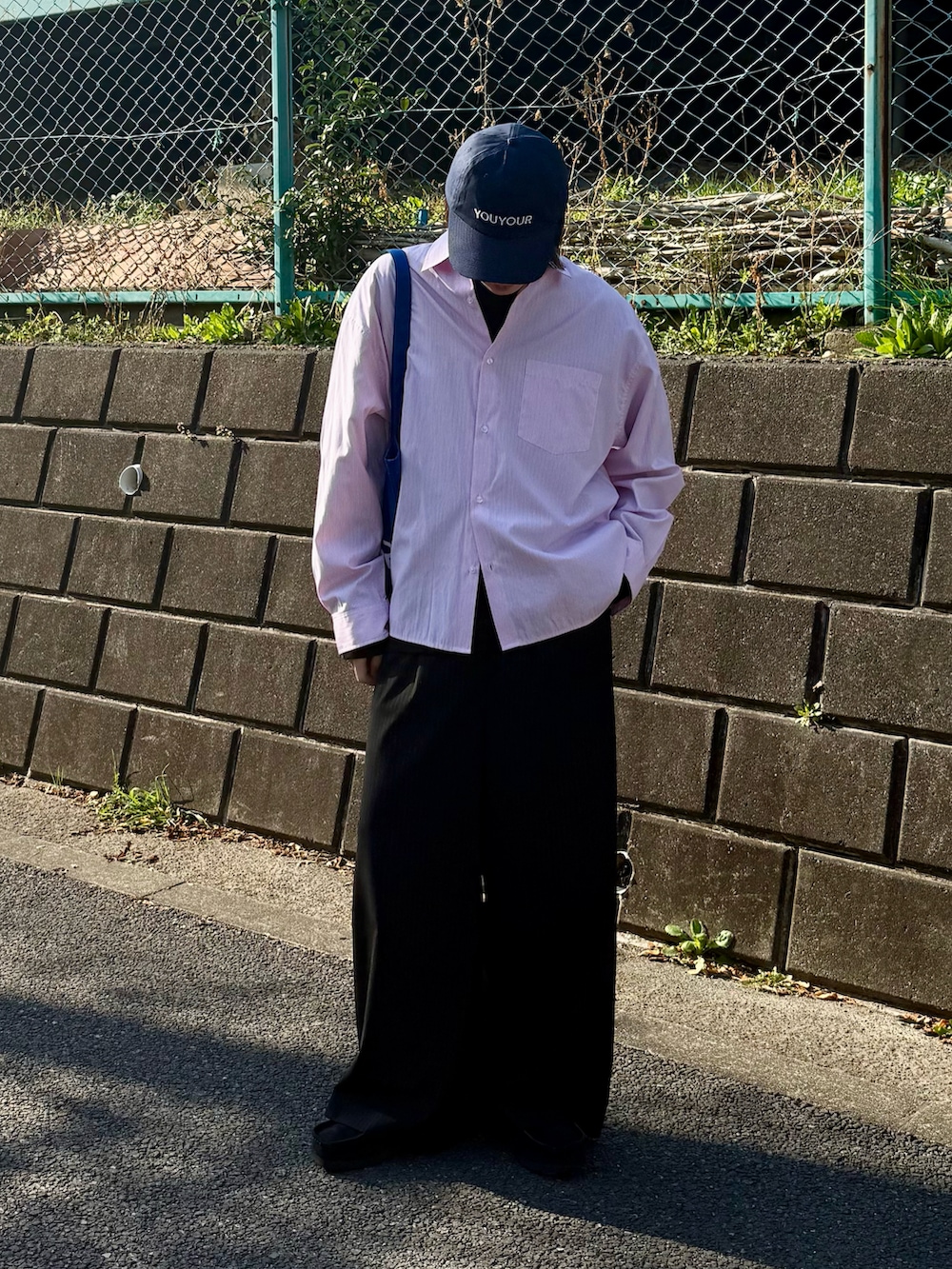 ピンク系のシャツ/ブラウス、ブラック系のスラックス、ブラック系のTシャツ/カットソーを着用したメンズの春コーディネートの2枚目の写真