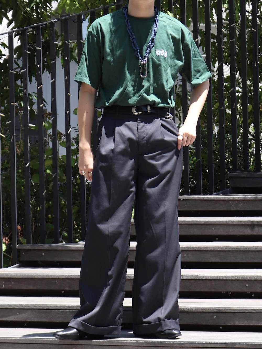 グリーン系のTシャツ/カットソー、グレー系のスラックス、ブルー系のウォレットチェーンを着用したメンズの夏コーディネートの5枚目の写真