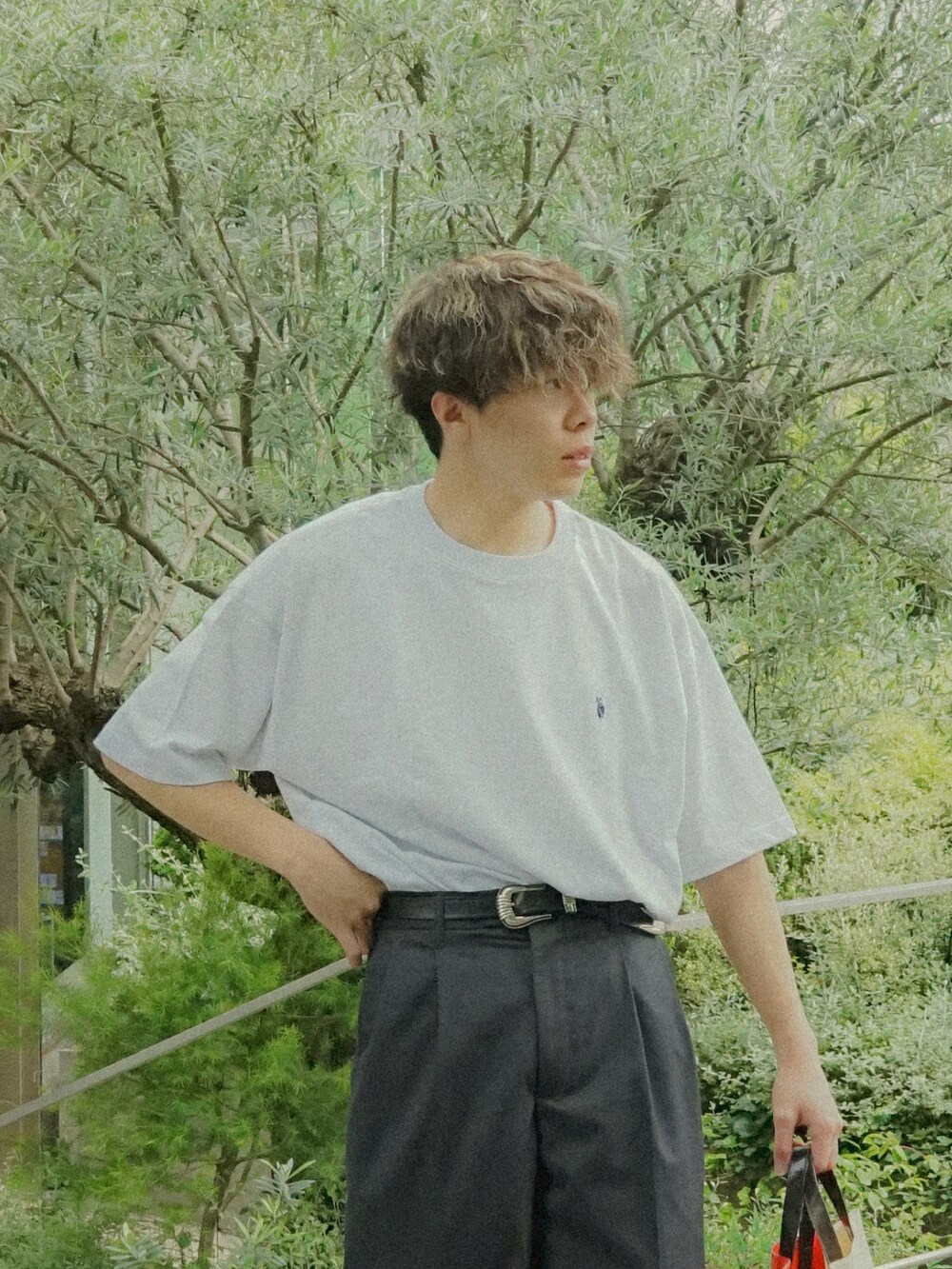 グレー系のTシャツ/カットソー、グレー系のスラックス、ホワイト系のトートバッグを着用したメンズの春コーディネートの4枚目の写真