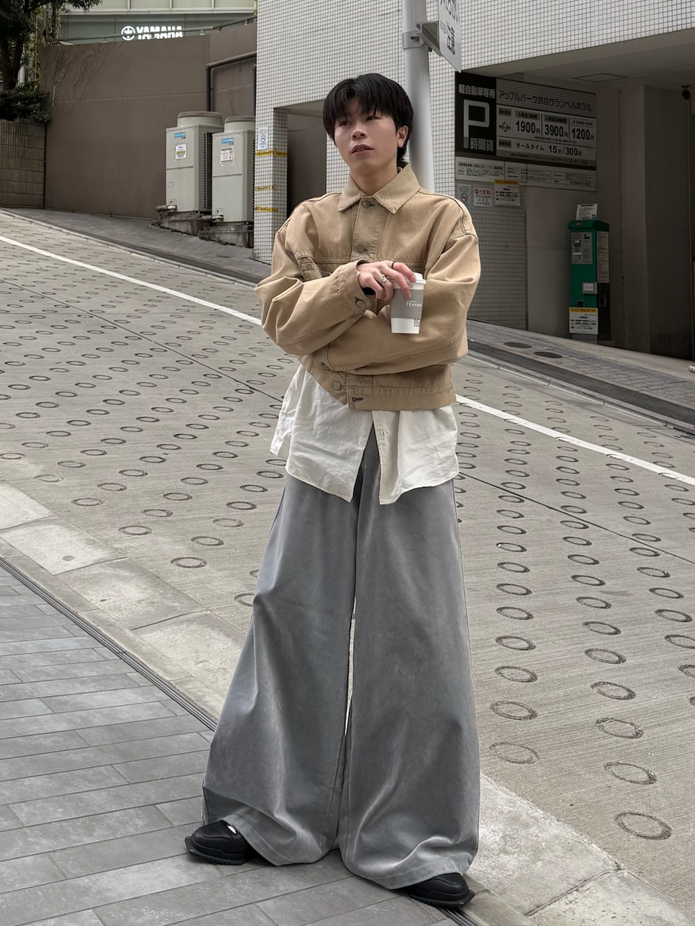 ベージュ系のデニムジャケット、グレー系のスウェットパンツ、ブラック系のスニーカーを着用したメンズの冬コーディネートの2枚目の写真