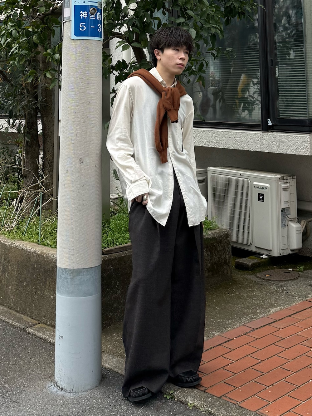 ブラウン系のカーディガン/ボレロ、ブラウン系のスラックス、ブラック系のローファーを着用したメンズの春コーディネートの3枚目の写真