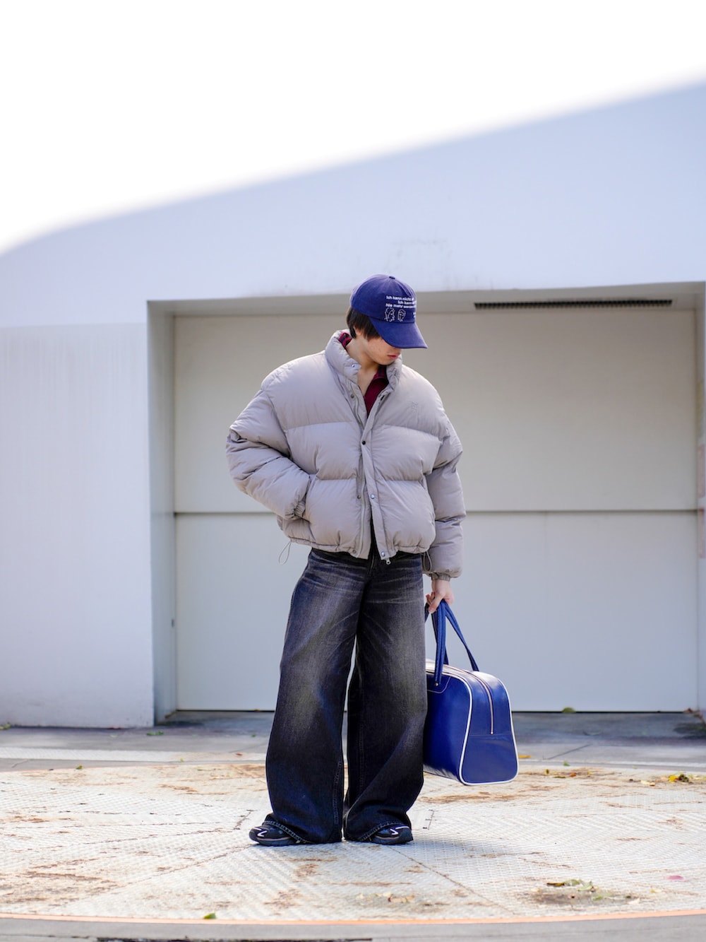 グレー系のダウンジャケット/コート、レッド系のその他トップス、ブラック系のデニムパンツを着用したメンズの秋コーディネートの3枚目の写真