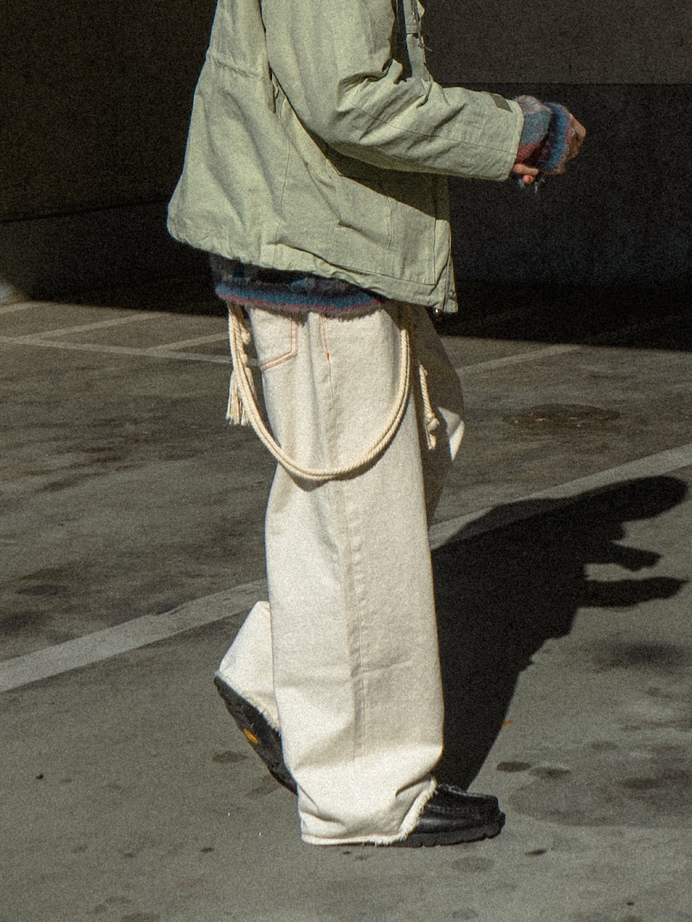 ベージュ系のマウンテンパーカー、ブラック系のデニムパンツ、ブラック系のブーツを着用したメンズの冬コーディネートの4枚目の写真