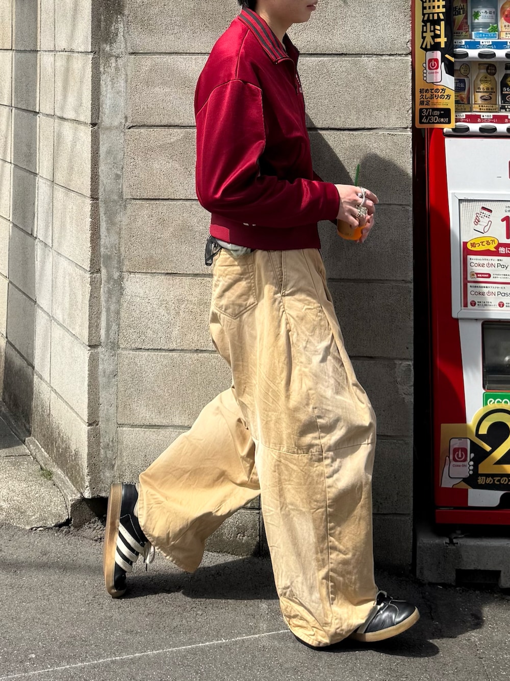 レッド系のその他トップス、ベージュ系のチノパンツ、ブラック系のスニーカーを着用したメンズの春コーディネートの2枚目の写真