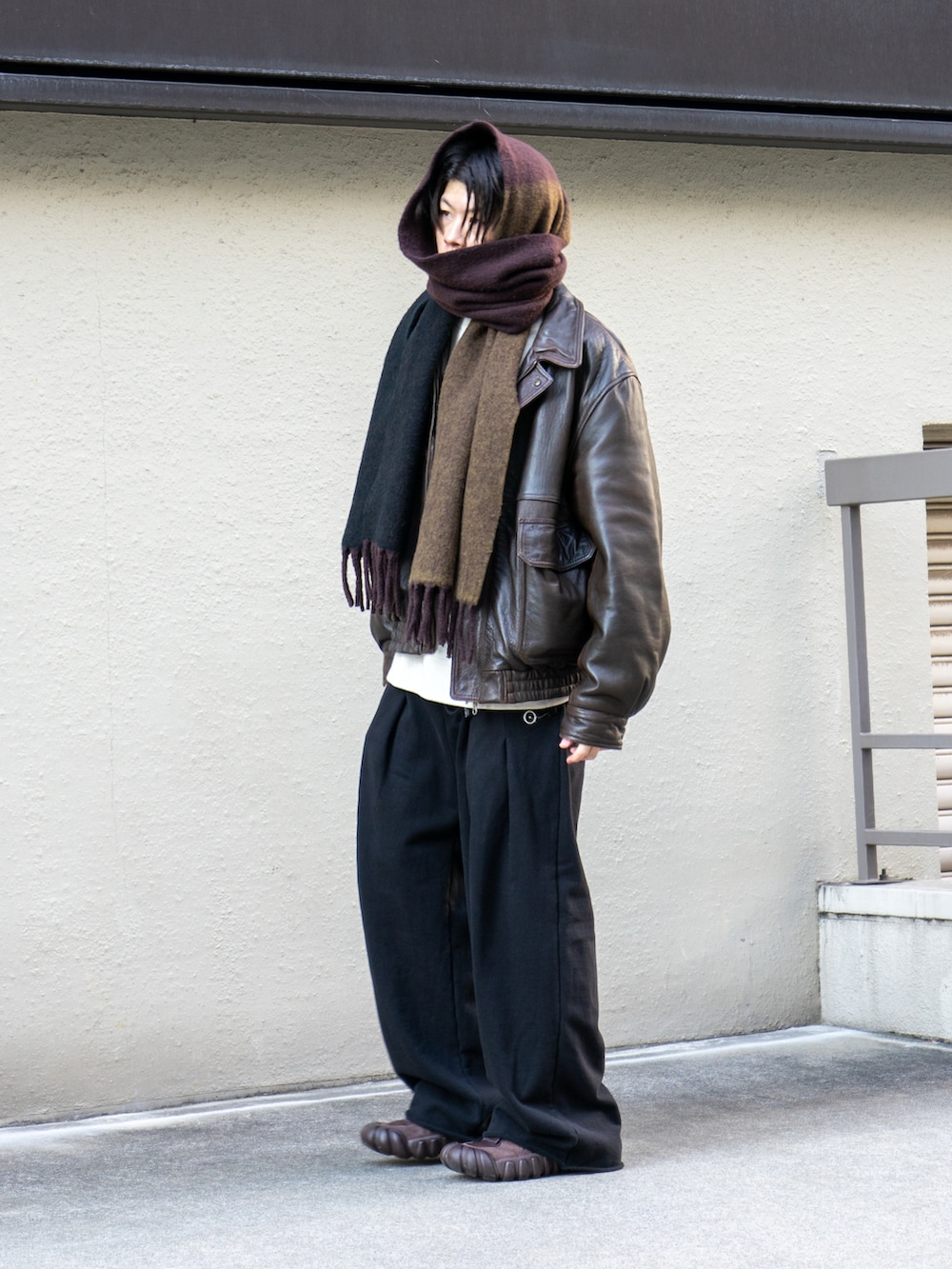 ブラウン系のブルゾン、ブラック系のスウェットパンツ、ブラウン系のスニーカーを着用したメンズの冬コーディネートの2枚目の写真