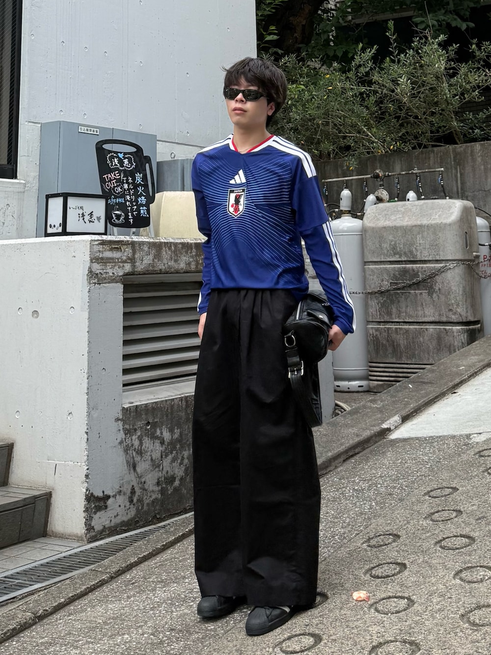 ブルー系のTシャツ/カットソー、ブラック系のその他パンツ、ブラック系のショルダーバッグを着用したメンズの夏コーディネートの4枚目の写真