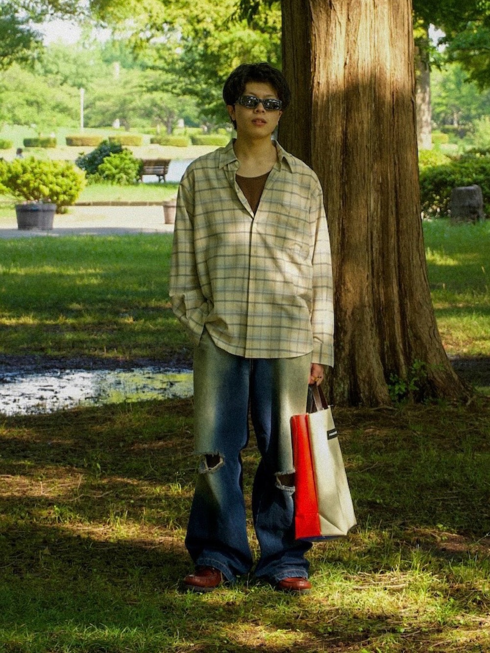 ベージュ系のシャツ/ブラウス、ブラウン系のタンクトップ、ブルー系のデニムパンツを着用したメンズの夏コーディネートの2枚目の写真