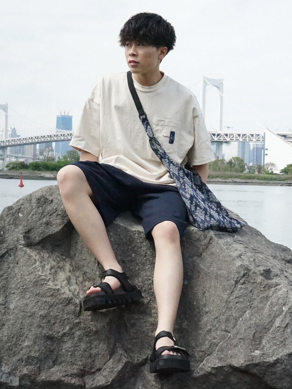 ベージュ系のTシャツ/カットソー、ブルー系のスウェットパンツ、ブルー系のショルダーバッグを着用したメンズの春コーディネートの2枚目の写真