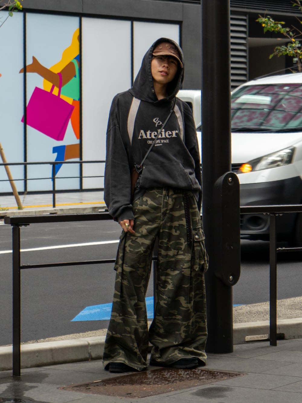 ブラック系のパーカー、その他のカーゴパンツ、ブラウン系のショルダーバッグを着用したメンズの秋コーディネートの2枚目の写真