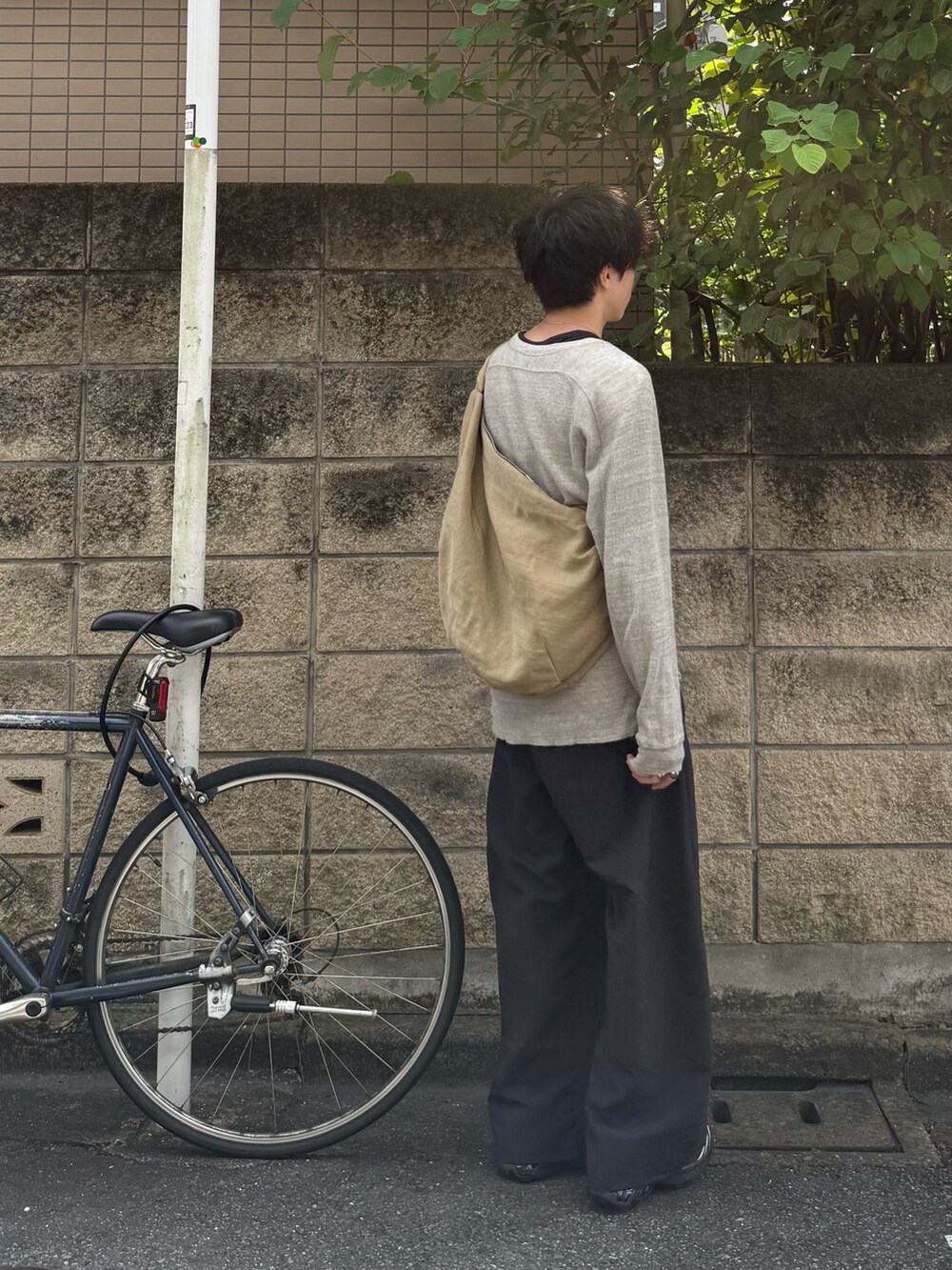 グレー系のTシャツ/カットソー、ブルー系のタンクトップ、グレー系のスラックスを着用したメンズの秋コーディネートの3枚目の写真