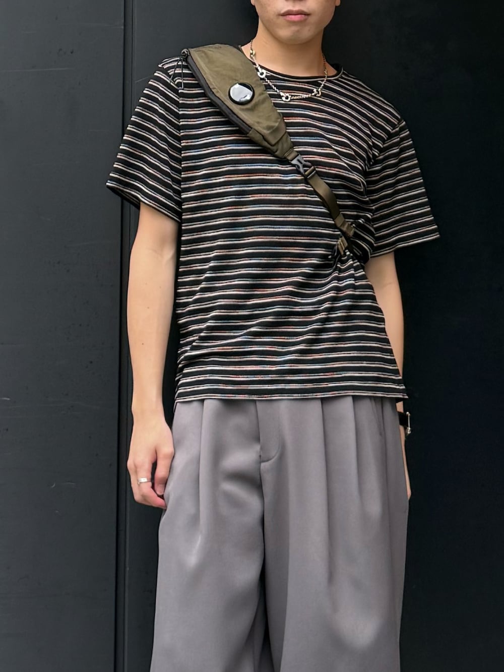 ブラック系のTシャツ/カットソー、グレー系のパンツ、グリーン系のバックパック/リュックを着用したメンズの夏コーディネートの2枚目の写真